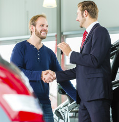 test Young man and seller with auto in car dealership