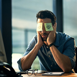 test Sleeping employee with sticky notes covering his eyes