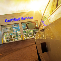 Car Service Auto Care Center. Car in Front of Two Gates to Authorized Certified Auto Service.
