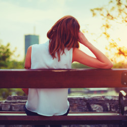 Girl enjoying city view from a bench in sunset / sunrise time.