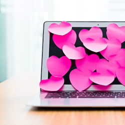 Laptop screen covered by group of pink heart shape adhesive notes