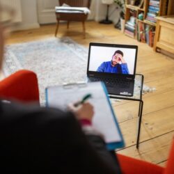 Man having a cognitive behavioral therapy video call with mental health professional